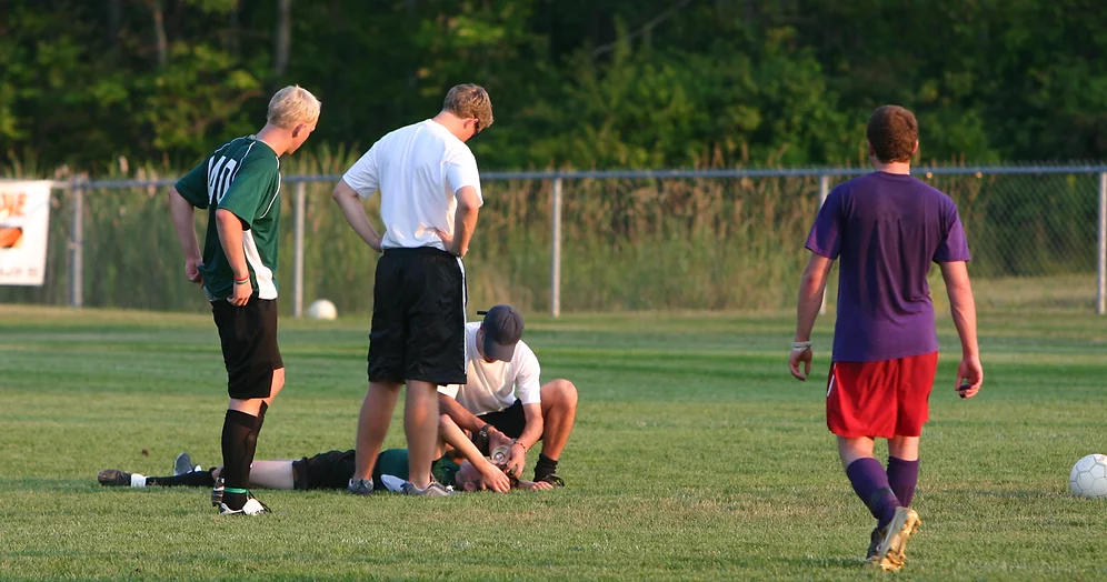 Équipe de soccer aide un joueur blessé